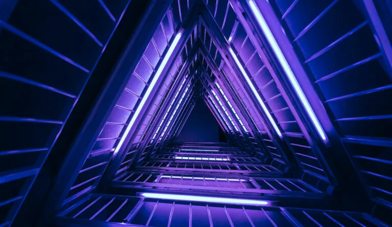 Neon-lit triangular tunnel with blue and purple glowing lines converging toward vanishing point